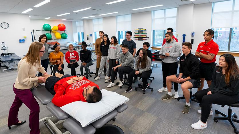 Image of Doctor of Physical 的rapy students observe a technique during a class at the DPT Skills Lab. 